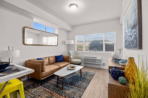 A living room with a brown couch and a yellow stool.