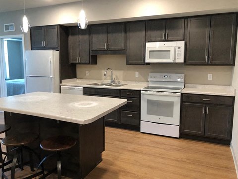A kitchen with a white counter top and black cabinets.