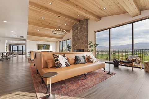 A modern living room with a large couch and a view of the mountains.