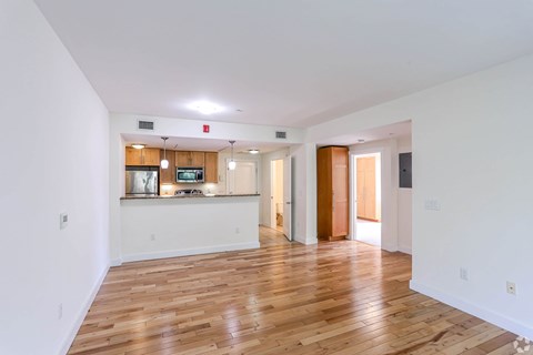 A spacious room with wooden floors and white walls.