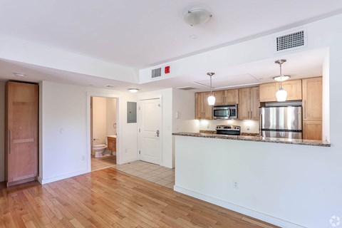A kitchen with a wooden counter top and a microwave.