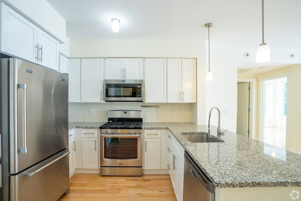 A kitchen with a granite countertop and stainless steel appliances at 603 Concord Apartments, Massachusetts
