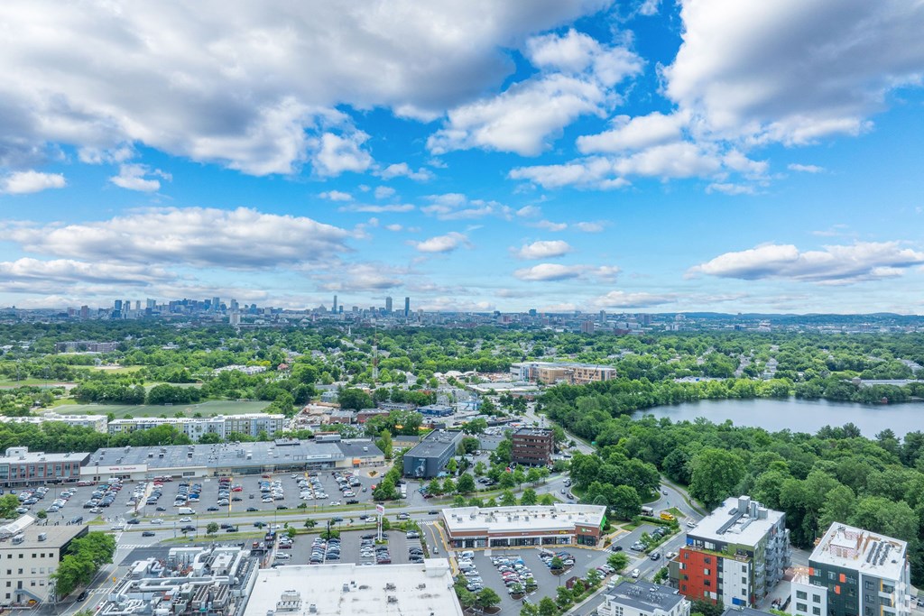 A cityscape with a mix of buildings and greenery under a blue sky with clouds at 603 Concord Apartments, Massachusetts
