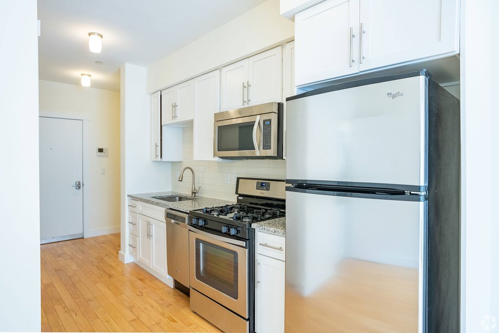 A kitchen with a black fridge and stove top oven at 603 Concord Apartments, Cambridge, Massachusetts