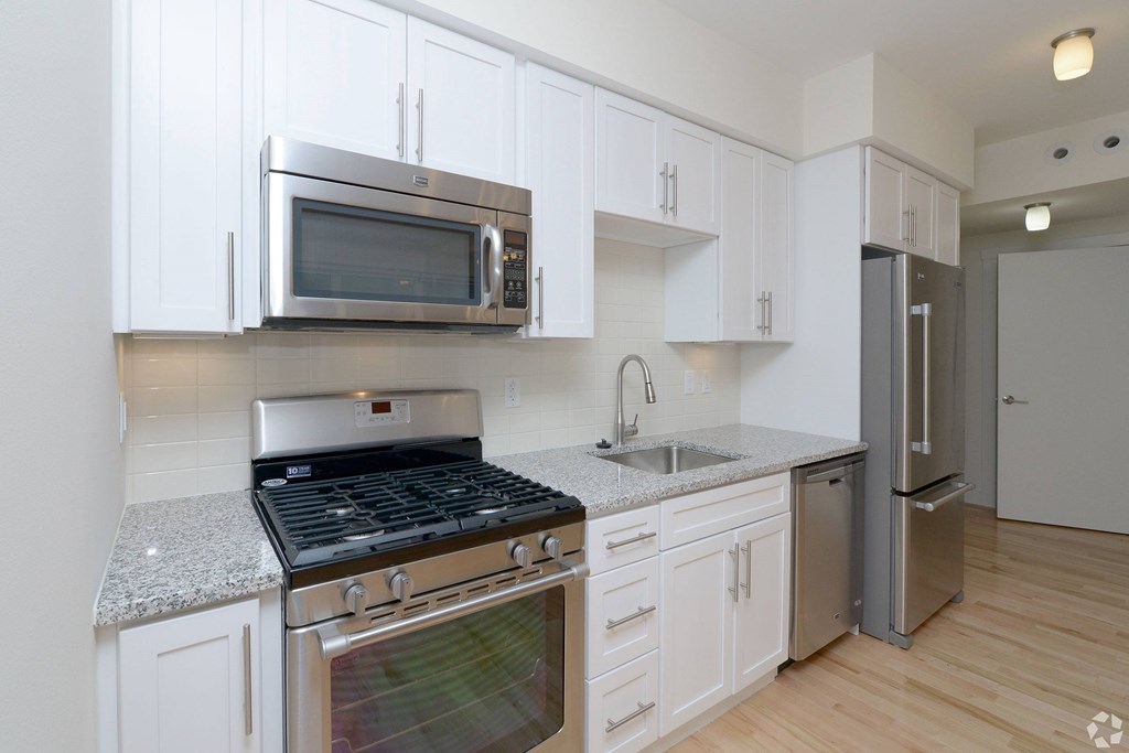 A kitchen with white cabinets and stainless steel appliances at 603 Concord Apartments, Cambridge 02138