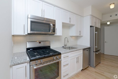 A kitchen with white cabinets and stainless steel appliances.