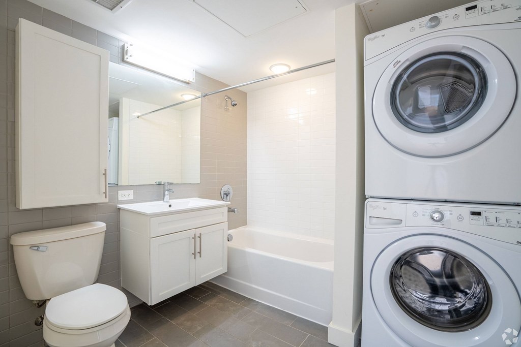 A white bathroom with a washing machine in the corner at 603 Concord Apartments, Massachusetts