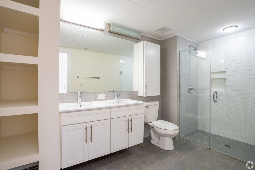 A white bathroom with a toilet, sink, and shower at 603 Concord Apartments, Cambridge
