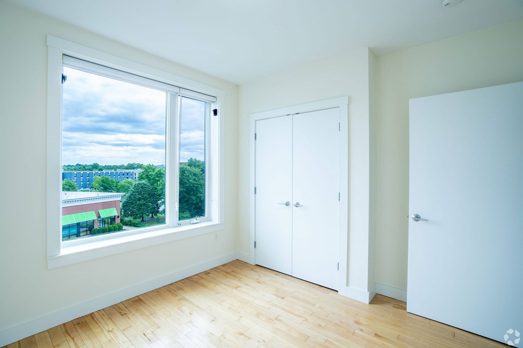 A room with a large window overlooking a cityscape at 603 Concord Apartments, Massachusetts