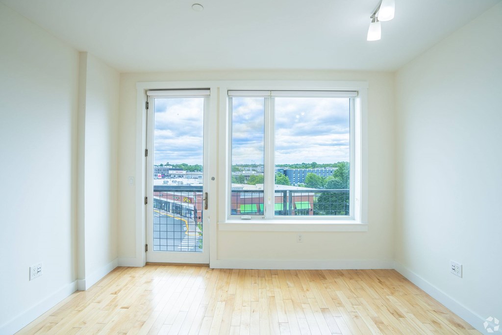 A room with a view of a parking lot through the windows at 603 Concord Apartments, Cambridge, Massachusetts