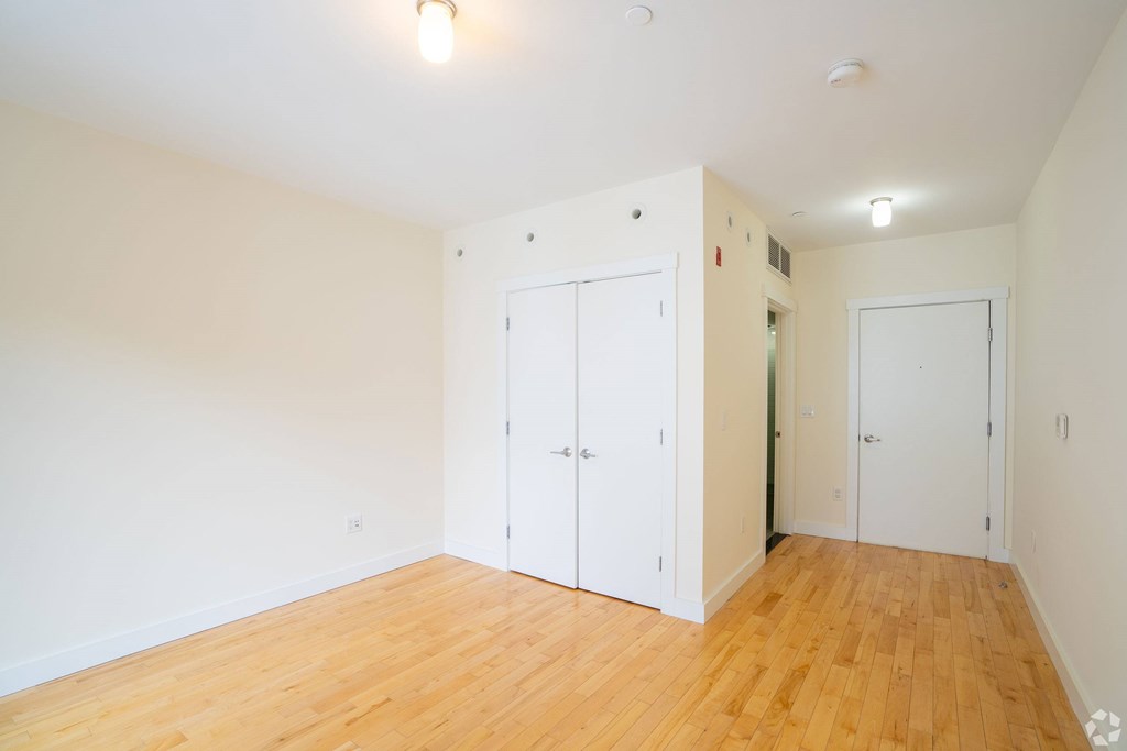 A room with white walls and wooden flooring with two white doors. at 603 Concord Apartments, Cambridge 02138