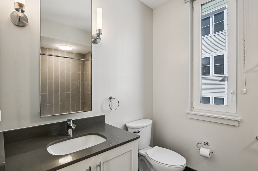 Bathroom with a sink and mirror at Park77 Apartments, Cambridge