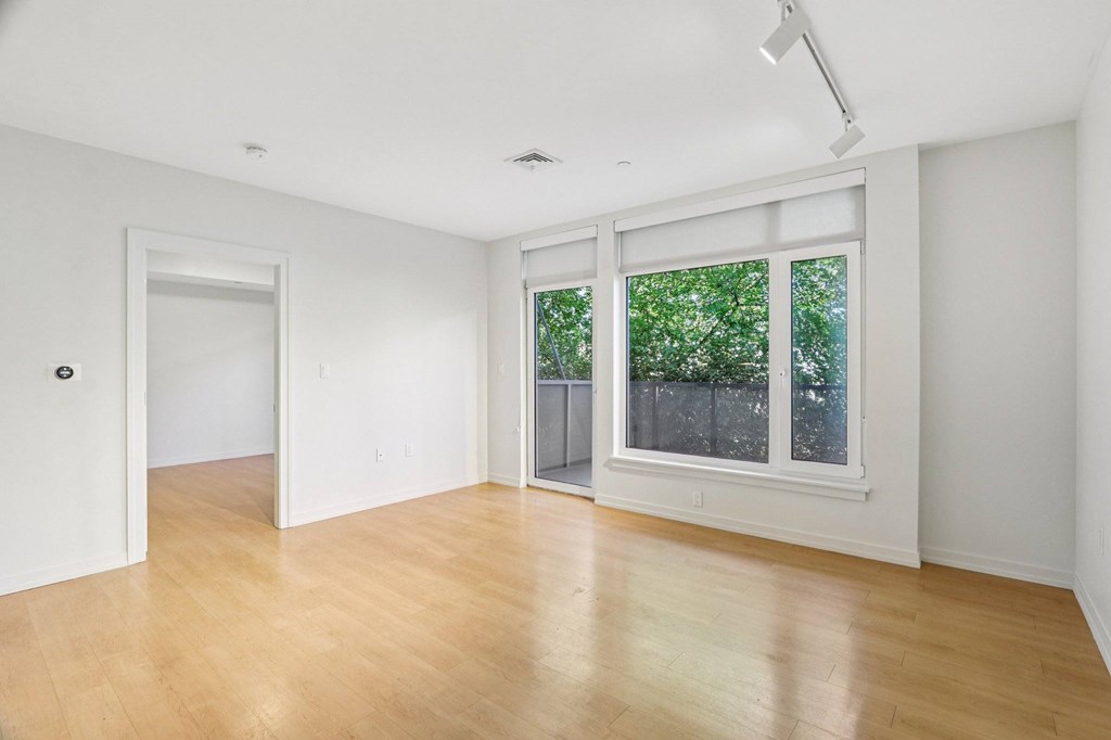 Living room with wooden floor and patio at Park77 Apartments, Massachusetts, 02138