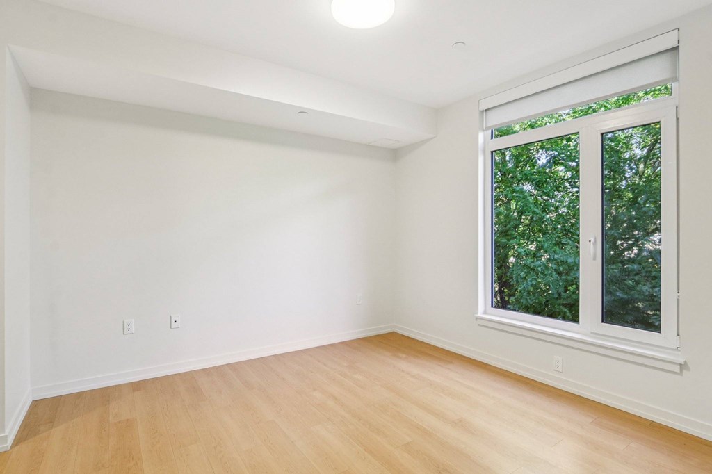Bedroom with oversized windows and wooden floor at Park77 Apartments, Massachusetts