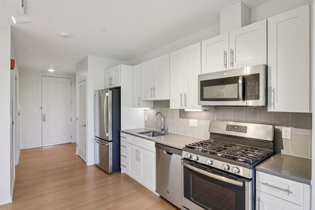 Kitchen with stove top oven and refrigerator at Park77 Apartments, Cambridge