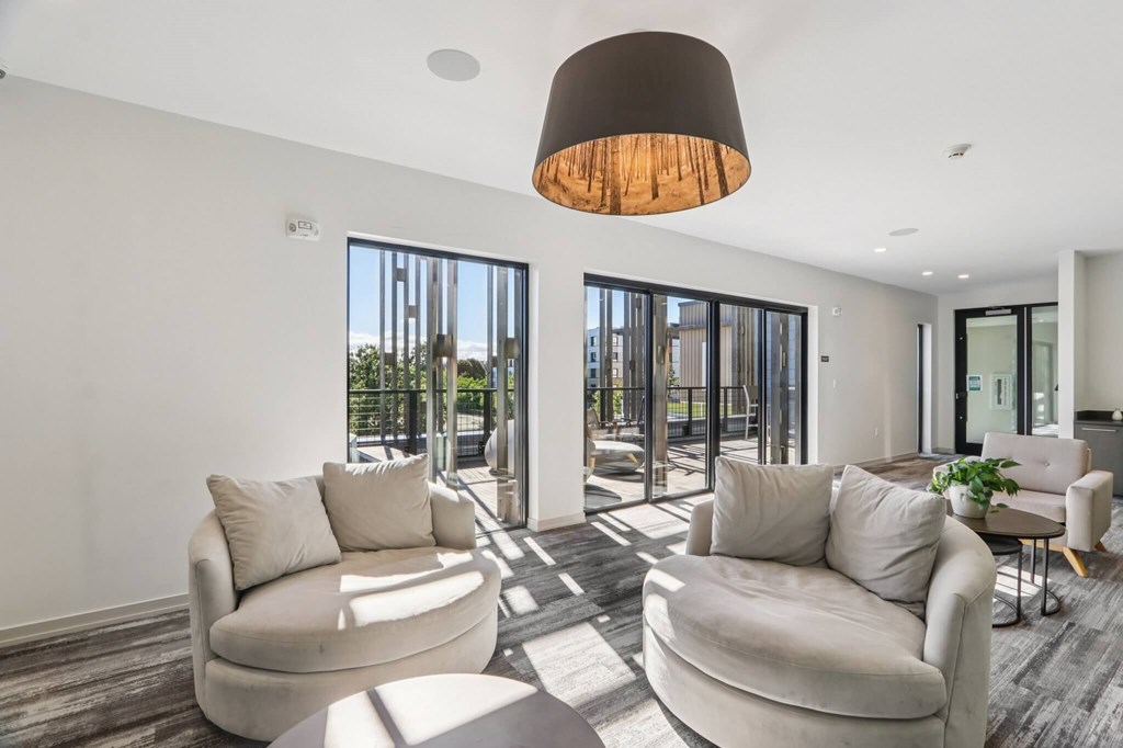 Modern living room with a large window and a view of the city at Park77 Apartments, Cambridge, MA