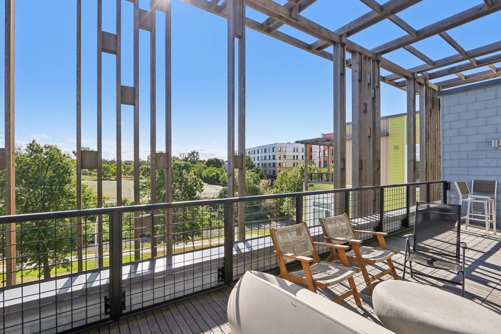Balcony with a table and chairs overlooking a green area at Park77 Apartments, Cambridge, 02138
