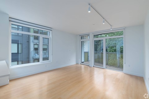 A spacious room with wooden floors and large windows at 605 Concord at Fresh Pond, Cambridge