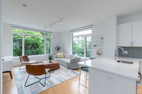 A modern kitchen with white cabinets and a white island.