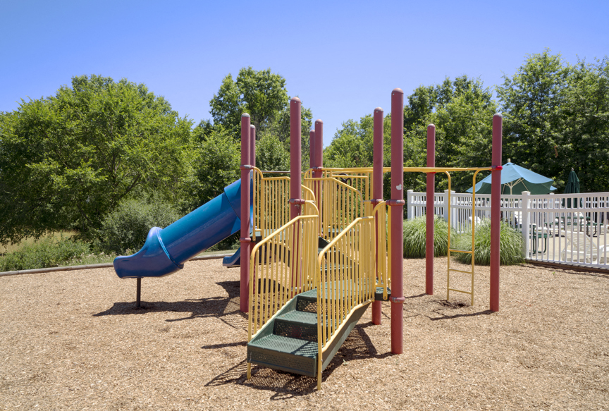 a playground with a blue slide and stairs