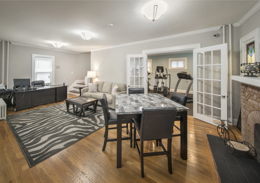 a living room with a dining room table and a fireplace