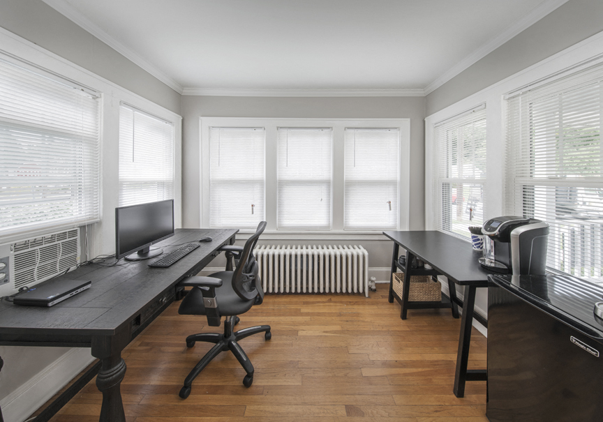 a home office with two desks and a desktop computer