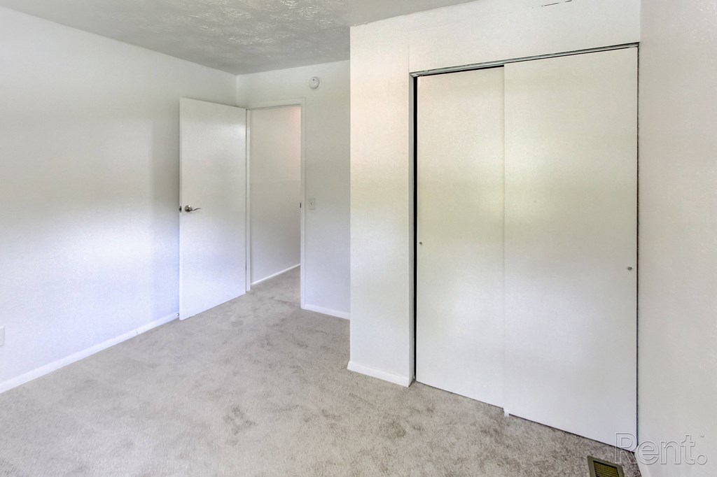 A room with two white doors and a carpeted floor.