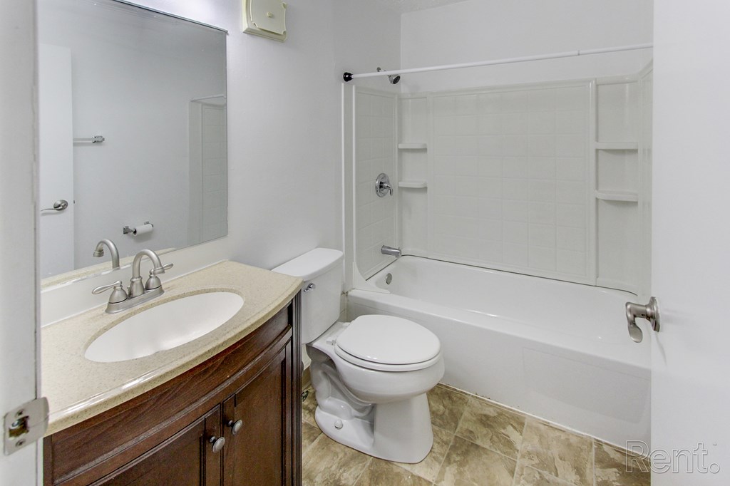A white toilet is next to a sink in a bathroom.