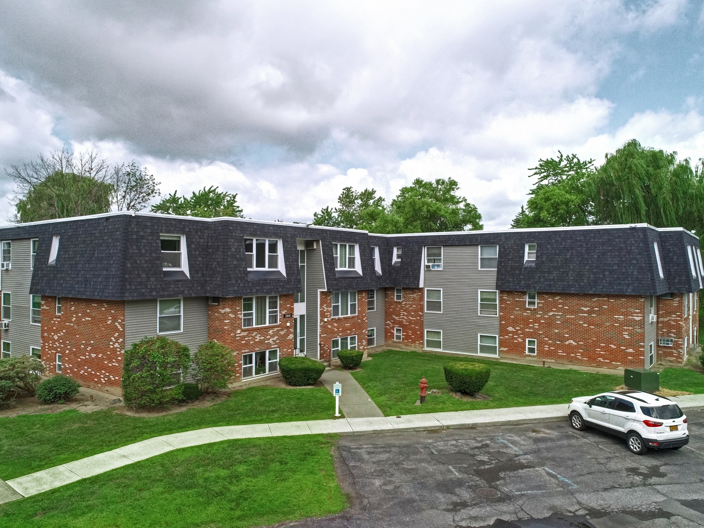an aerial view of an apartment building with a car parked in front