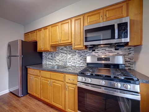 A kitchen with wooden cabinets and a black stove top oven.