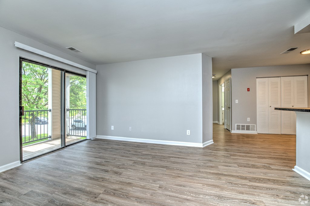 an empty living room with sliding glass doors to a balcony