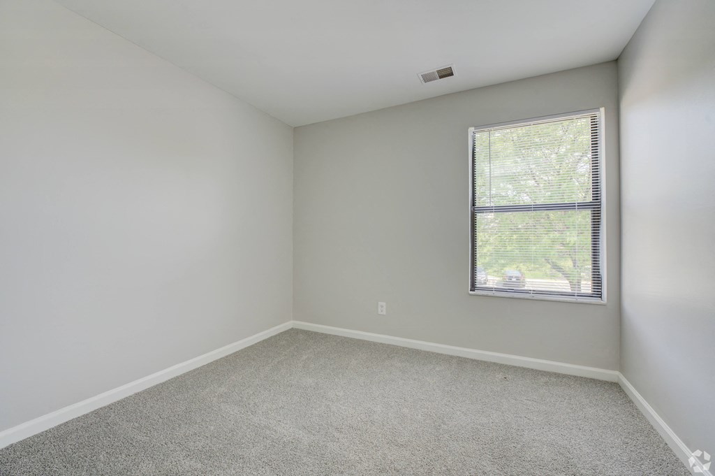 an empty room with white walls and a window