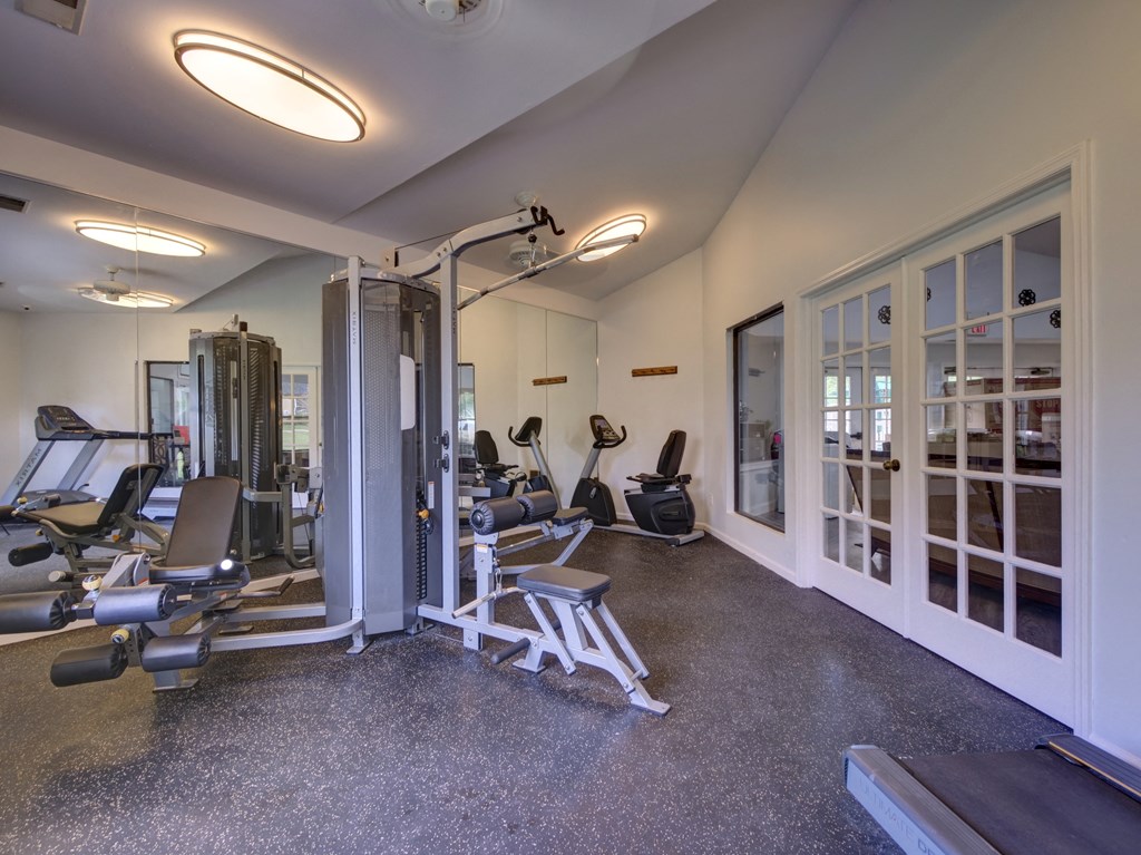 a gym with exercise equipment and glass doors