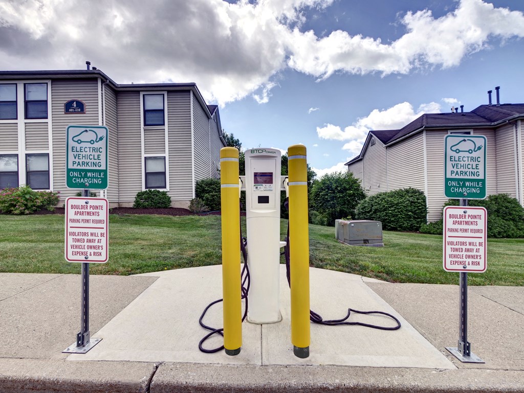 a white and yellow gas pump with two signs in front of it