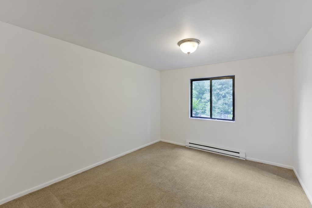an empty room with white walls and a window