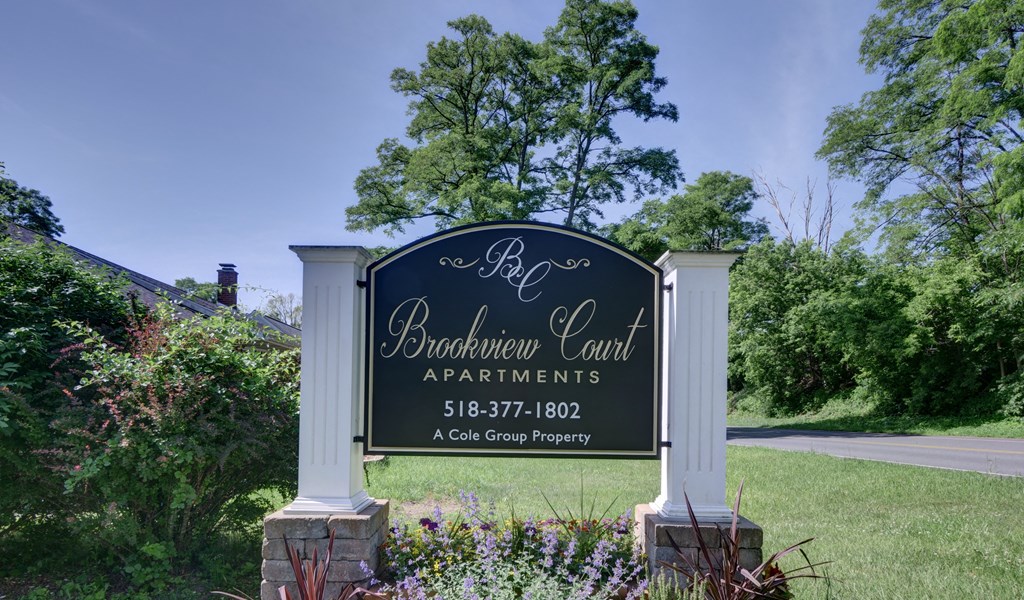 the sign for the broadway court apartments entrance to the property