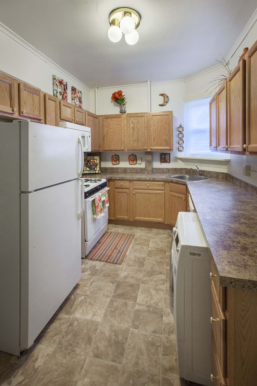 a kitchen with white appliances and wooden cabinets