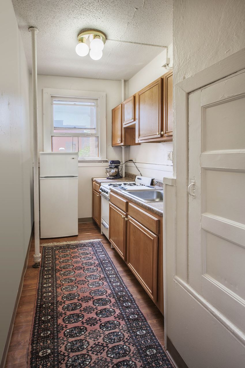 a small kitchen with a rug in the middle of the floor