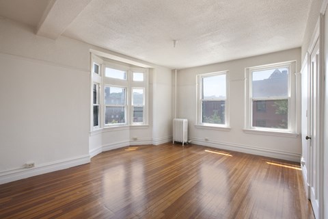 an empty living room with wood floors and windows
