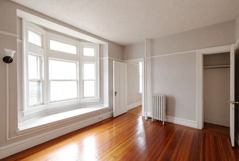 an empty room with wood floors and a window