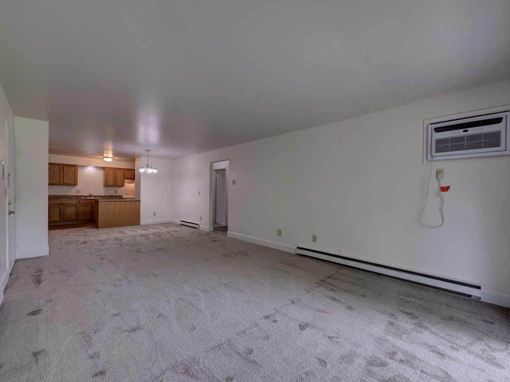 the living room and kitchen of an empty house with white walls