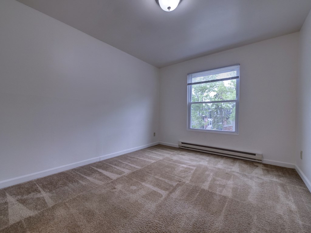an empty room with carpet and a window