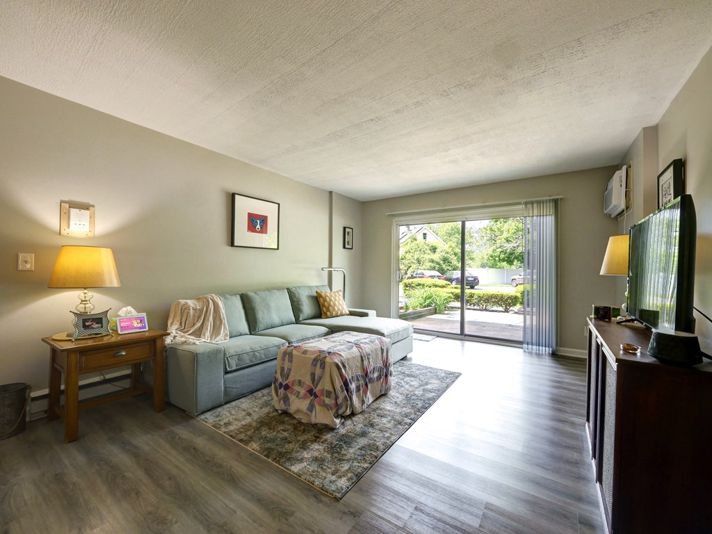 Lliving room has a large sliding glass door to the patio at Cedar Park Apartments, Troy, 12180