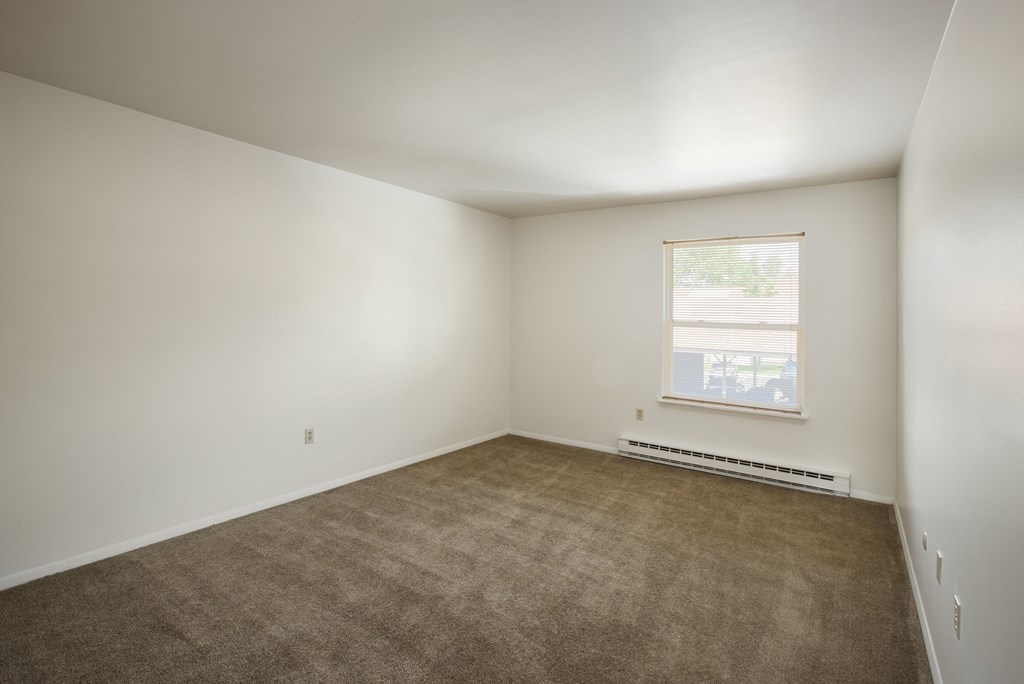 an empty room with carpet and a window