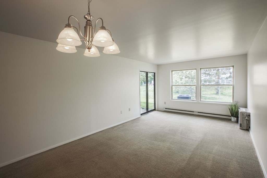 an empty living room with white walls and a window