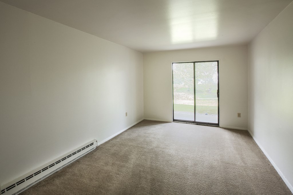 an empty room with white walls and a glass door