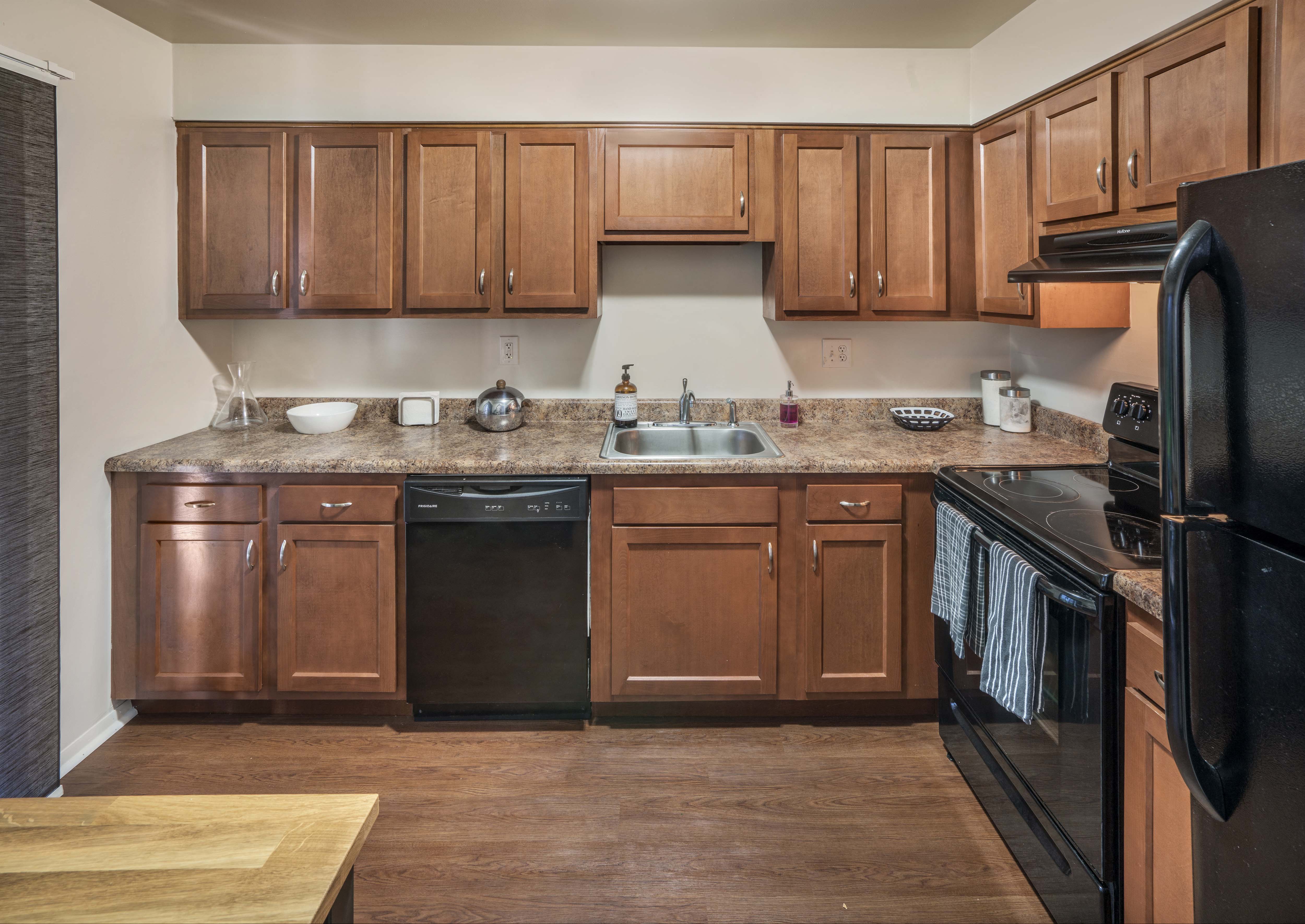 a kitchen with wooden cabinets and black appliances