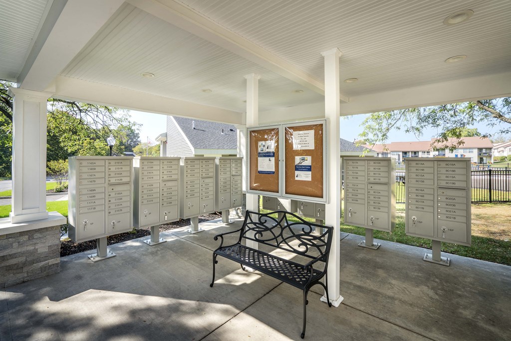 a bench in front of a row of mailboxes on a porch