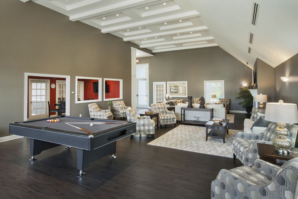 a large living room with a pool table in the center of it