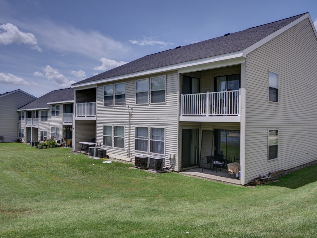 a view of an apartment building with a yard in front of it